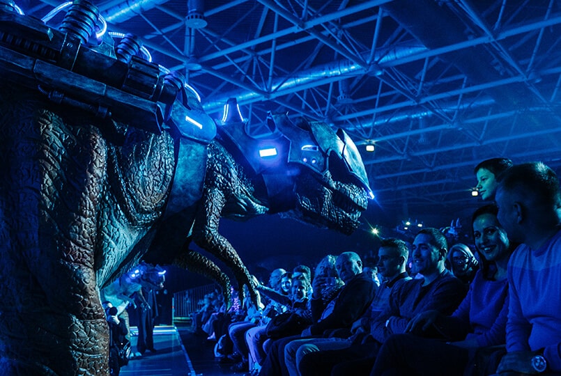 Живой динозавр в космическом стиле приветствует зрителей